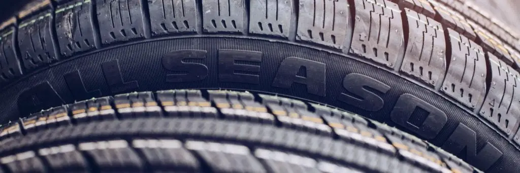 Close-up of the sidewalls of two stacked tires. The focus is on the text ALL SEASON embossed on the nearest tire, highlighting its all-season utility. The treads are visible, suggesting durability and grip. Superior Tire: Tire Shop and Auto Repair Near Me | Barrie | Danforth | Downsview | Markham | Mississauga | Oak Ridges | Scarborough | Thornhill | Toronto | https://superiortire.ca/