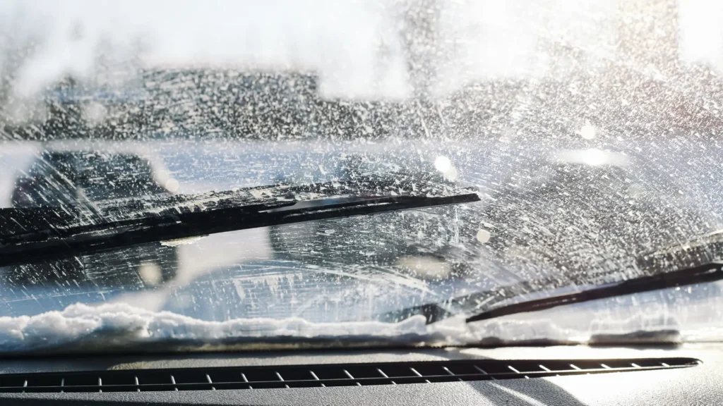 View from inside a car looking through a windshield being cleaned by wipers, with water and soap suds blurring the outside scene—a reminder that regular maintenance helps maximize vehicle lifespan. Superior Tire: Tire Shop and Auto Repair Near Me | Barrie | Danforth | Downsview | Markham | Mississauga | Oak Ridges | Scarborough | Thornhill | Toronto | https://superiortire.ca/