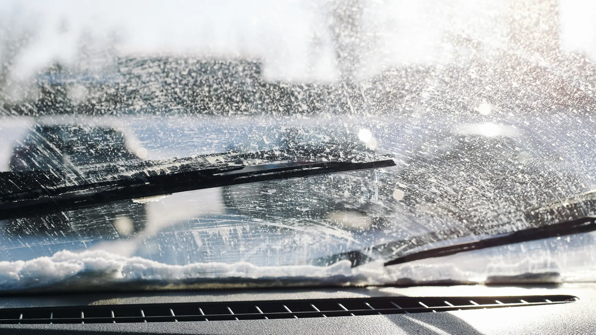 View from inside a car looking through a windshield being cleaned by wipers, with water and soap suds blurring the outside scene—a reminder that regular maintenance helps maximize vehicle lifespan. Superior Tire: Tire Shop and Auto Repair Near Me | Barrie | Danforth | Downsview | Markham | Mississauga | Oak Ridges | Scarborough | Thornhill | Toronto | https://superiortire.ca/
